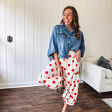 Soft, stretchy cream elastic drawstring waist pants with large red polka dots throughout, pockets and button cuffs for a balloon-like silhouette.