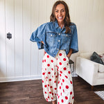 Soft, stretchy cream elastic drawstring waist pants with large red polka dots throughout, pockets and button cuffs for a balloon-like silhouette.