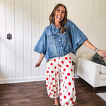 Soft, stretchy cream elastic drawstring waist pants with large red polka dots throughout, pockets and button cuffs for a balloon-like silhouette.