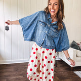 Soft, stretchy cream elastic drawstring waist pants with large red polka dots throughout, pockets and button cuffs for a balloon-like silhouette.