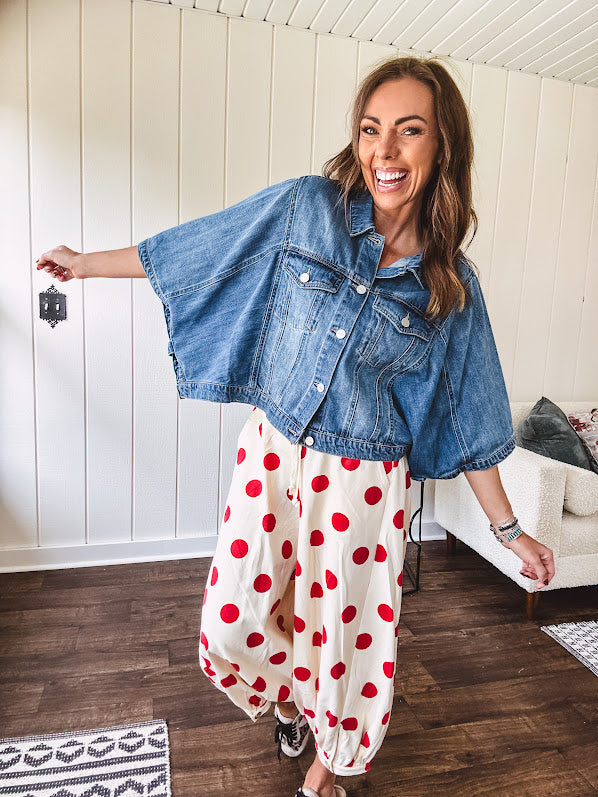 Soft, stretchy cream elastic drawstring waist pants with large red polka dots throughout, pockets and button cuffs for a balloon-like silhouette.