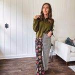 Lightweight denim-like non-stretch wide leg pants with elastic back waist, side and back pockets, button and zipper closure and black and cream stripes on one leg and funky leopard, heart, eye graphics on a black background on the other.