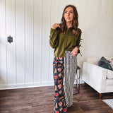 Lightweight denim-like non-stretch wide leg pants with elastic back waist, side and back pockets, button and zipper closure and black and cream stripes on one leg and funky leopard, heart, eye graphics on a black background on the other.