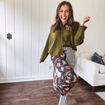 Lightweight denim-like non-stretch wide leg pants with elastic back waist, side and back pockets, button and zipper closure and black and cream stripes on one leg and funky leopard, heart, eye graphics on a black background on the other.
