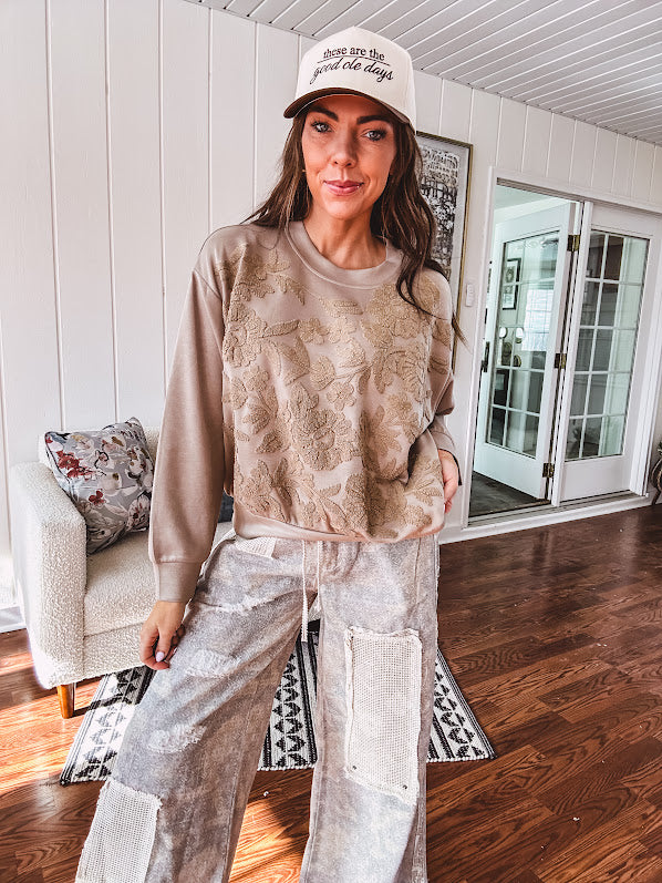 Taupe crew neck pullover with matching floral embroidery on the front.