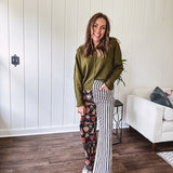 Lightweight denim-like non-stretch wide leg pants with elastic back waist, side and back pockets, button and zipper closure and black and cream stripes on one leg and funky leopard, heart, eye graphics on a black background on the other.