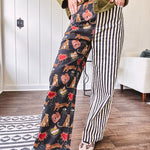 Lightweight denim-like non-stretch wide leg pants with elastic back waist, side and back pockets, button and zipper closure and black and cream stripes on one leg and funky leopard, heart, eye graphics on a black background on the other.