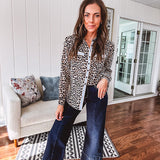 Thin, lightweight long sleeved button down top with leo print and contrasting blue, tan, white and red striping at the buttons and pockets.