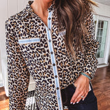 Thin, lightweight long sleeved button down top with leo print and contrasting blue, tan, white and red striping at the buttons and pockets.