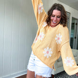 Soft, lightweight, nearly sheer knit pullover  with long sleeves, exposed seams at the shoulders and down the center with large daisy florals throughout. Available in multiple colors.
