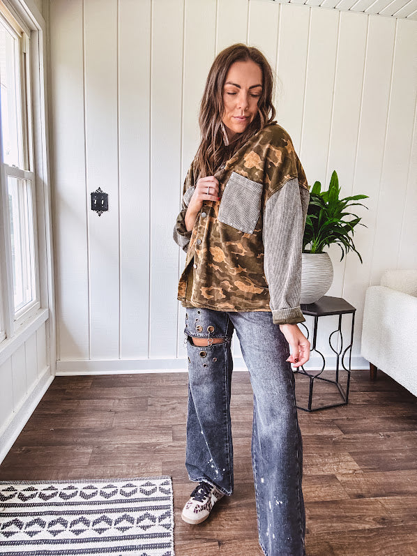 Lightweight button front camo jacket with olive and mustard colorway textured waffle weave on the sleeves and pockets, collar, metal buttons and tiny floral rivets throughout.