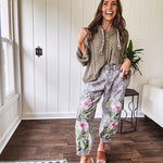 Lightweight washed black joggers with elastic back, floral button down closure and pink and green oversized floral embroidery down the front of both legs.