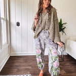 Lightweight washed black joggers with elastic back, floral button down closure and pink and green oversized floral embroidery down the front of both legs.