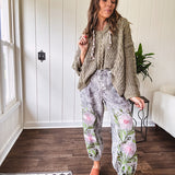 Lightweight washed black joggers with elastic back, floral button down closure and pink and green oversized floral embroidery down the front of both legs.