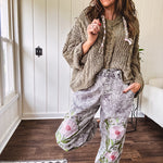 Lightweight washed black joggers with elastic back, floral button down closure and pink and green oversized floral embroidery down the front of both legs.