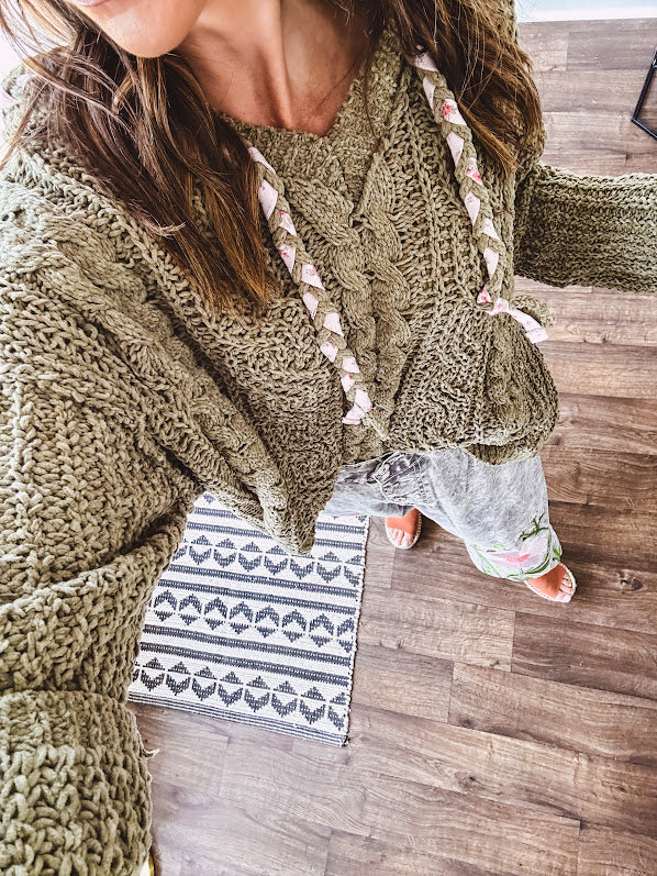 Chenille-like woven long sleeved sweater in light olive green with hoodie and matching rope ties with relaxed hem and fit.