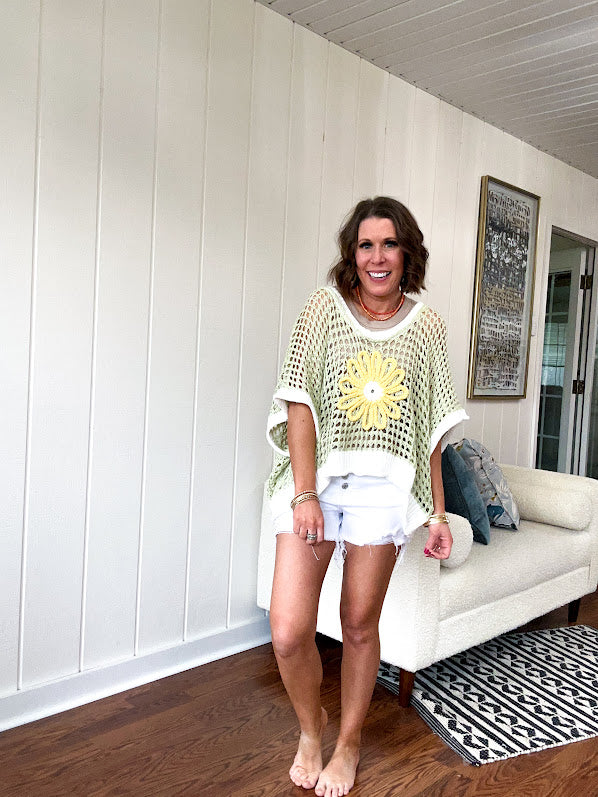 Open weave crochet sweater with 3/4 sleeves and large contrasting crochet flower on the front and contrasting trim. Oversized. Available in multiple colors.