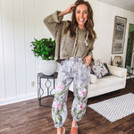 Lightweight washed black joggers with elastic back, floral button down closure and pink and green oversized floral embroidery down the front of both legs.