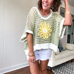 Open weave crochet sweater with 3/4 sleeves and large contrasting crochet flower on the front and contrasting trim. Oversized. Available in multiple colors.