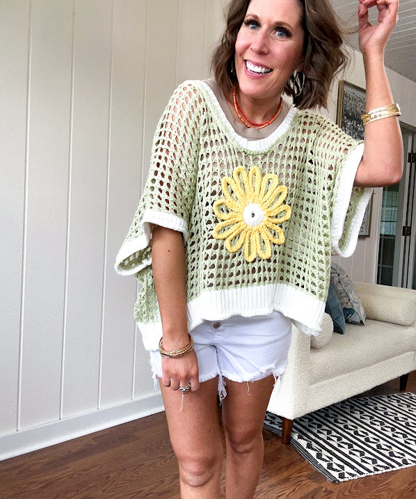 Open weave crochet sweater with 3/4 sleeves and large contrasting crochet flower on the front and contrasting trim. Oversized. Available in multiple colors.