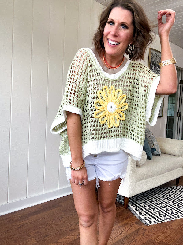 Open weave crochet sweater with 3/4 sleeves and large contrasting crochet flower on the front and contrasting trim. Oversized. Available in multiple colors.