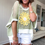 Open weave crochet sweater with 3/4 sleeves and large contrasting crochet flower on the front and contrasting trim. Oversized. Available in multiple colors.