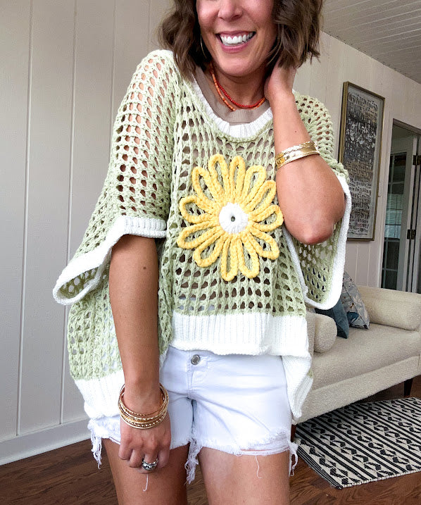Open weave crochet sweater with 3/4 sleeves and large contrasting crochet flower on the front and contrasting trim. Oversized. Available in multiple colors.