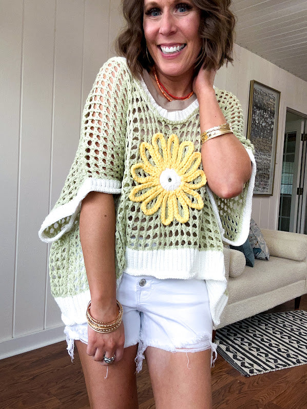 Open weave crochet sweater with 3/4 sleeves and large contrasting crochet flower on the front and contrasting trim. Oversized. Available in multiple colors.