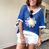 Open weave crochet sweater with 3/4 sleeves and large contrasting crochet flower on the front and contrasting trim. Oversized. Available in multiple colors.