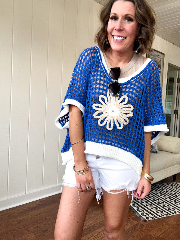 Open weave crochet sweater with 3/4 sleeves and large contrasting crochet flower on the front and contrasting trim. Oversized. Available in multiple colors.