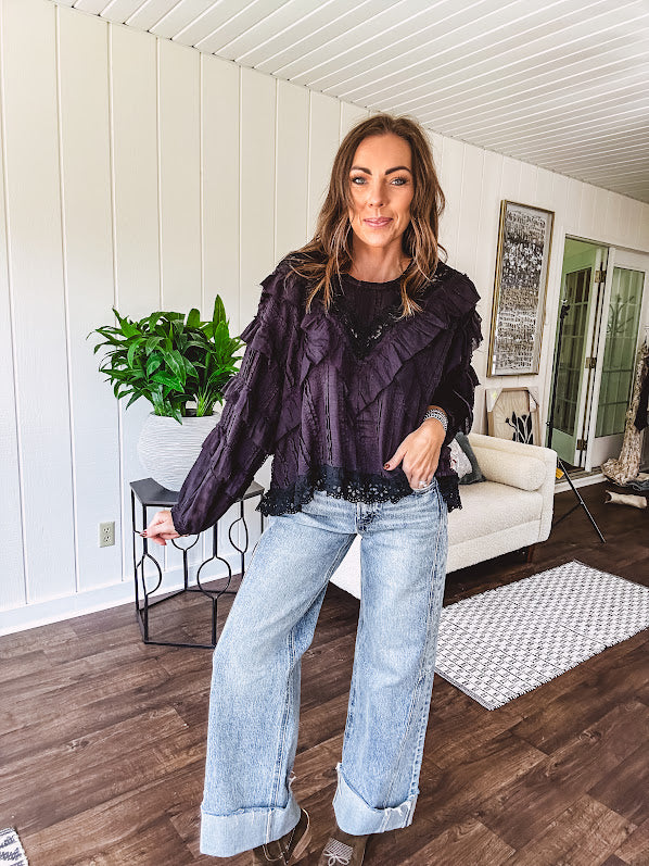 Black long sleeved blouse with lace and eyelet ruffle detail throughout.