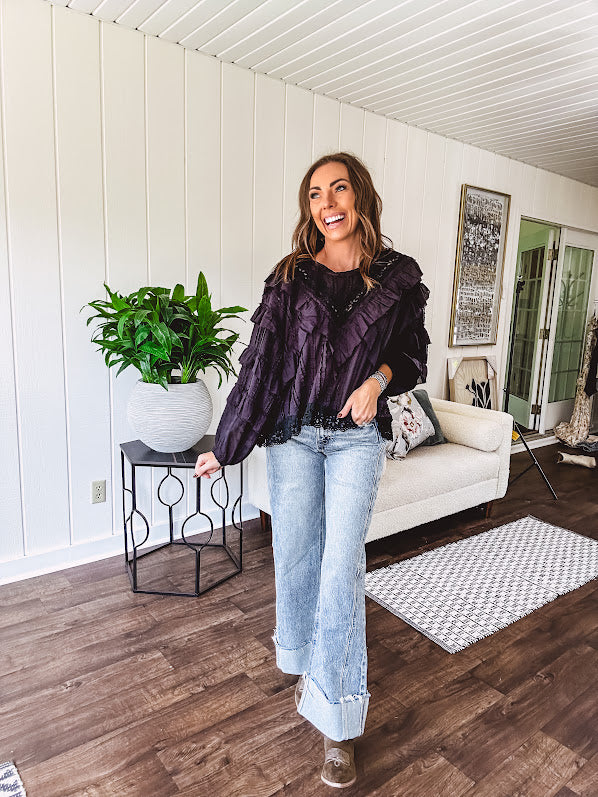 Black long sleeved blouse with lace and eyelet ruffle detail throughout.