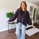 Black long sleeved blouse with lace and eyelet ruffle detail throughout.