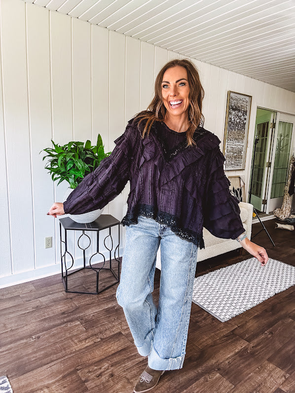 Black long sleeved blouse with lace and eyelet ruffle detail throughout.