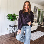 Black long sleeved blouse with lace and eyelet ruffle detail throughout.