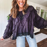 Black long sleeved blouse with lace and eyelet ruffle detail throughout.