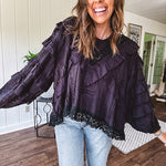 Black long sleeved blouse with lace and eyelet ruffle detail throughout.