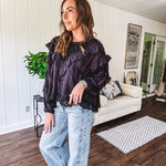 Black long sleeved blouse with lace and eyelet ruffle detail throughout.