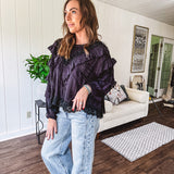 Black long sleeved blouse with lace and eyelet ruffle detail throughout.