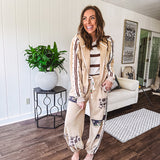 Lightweight, nearly sheet knit sweater with capped sleeves in cream with dark brown stripes and middle front seam detail.