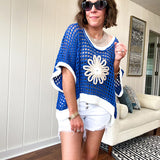 Open weave crochet sweater with 3/4 sleeves and large contrasting crochet flower on the front and contrasting trim. Oversized. Available in multiple colors.