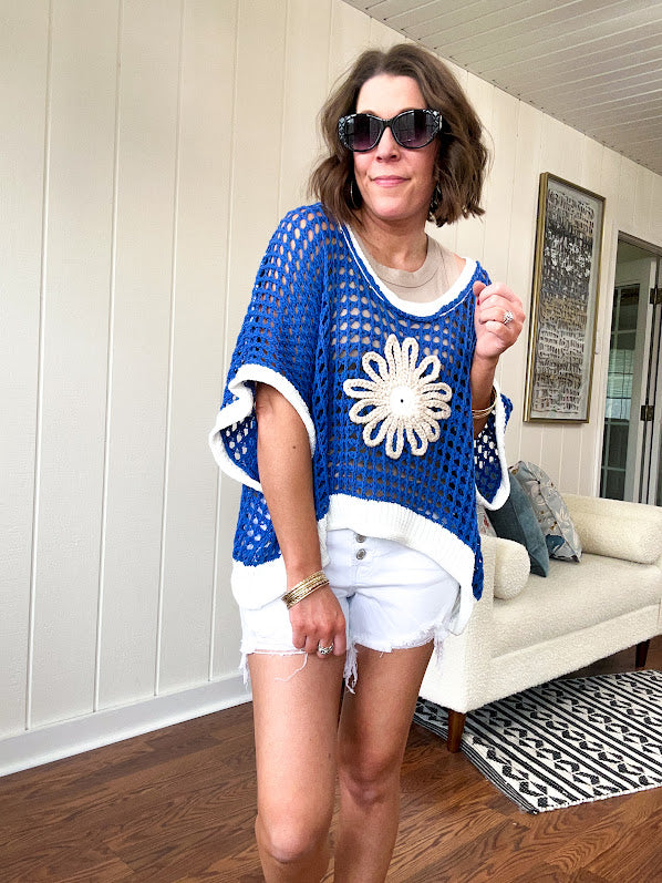 Open weave crochet sweater with 3/4 sleeves and large contrasting crochet flower on the front and contrasting trim. Oversized. Available in multiple colors.