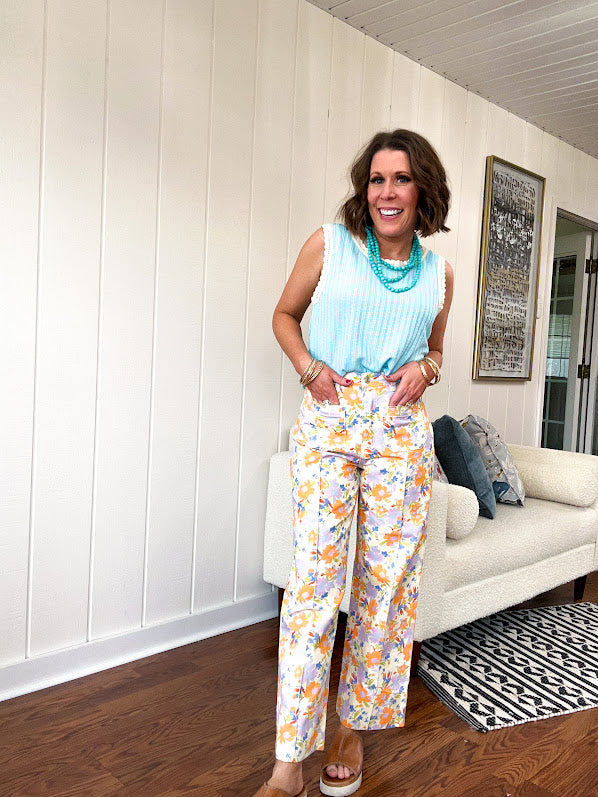 Cotton button and zipper closure bright floral pants with seams down the front of both legs and front and back pockets.