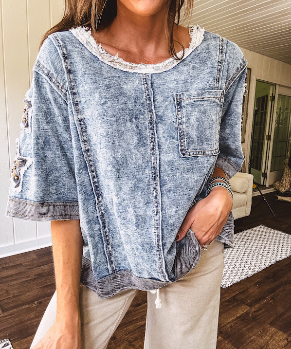 Crafted from a soft cotton-blend in a medium wash, this short-sleeved shirt features eye-catching floral and ribbed patchwork details that make it impossible to ignore. The relaxed fit, seam detailing, and front pocket keep things effortlessly comfortable, while the textured cuffs and hem add that signature boho edge.