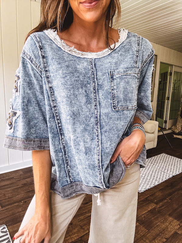 Crafted from a soft cotton-blend in a medium wash, this short-sleeved shirt features eye-catching floral and ribbed patchwork details that make it impossible to ignore. The relaxed fit, seam detailing, and front pocket keep things effortlessly comfortable, while the textured cuffs and hem add that signature boho edge.