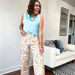 Cotton button and zipper closure bright floral pants with seams down the front of both legs and front and back pockets.