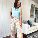 Cotton button and zipper closure bright floral pants with seams down the front of both legs and front and back pockets.
