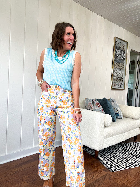 Cotton button and zipper closure bright floral pants with seams down the front of both legs and front and back pockets.