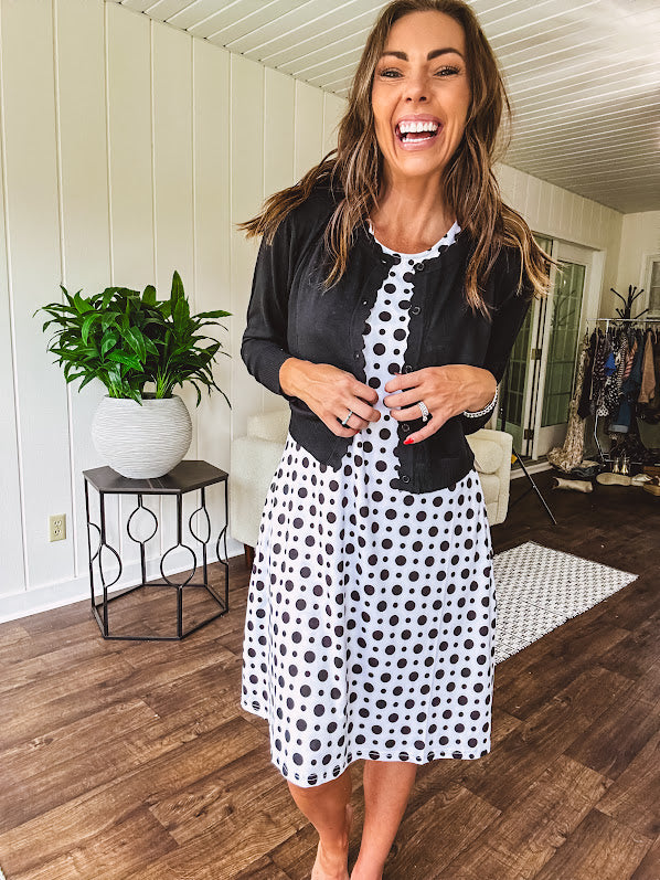 Lightweight, long sleeved black cardigan with button front and scalloped trim with cropped hem.