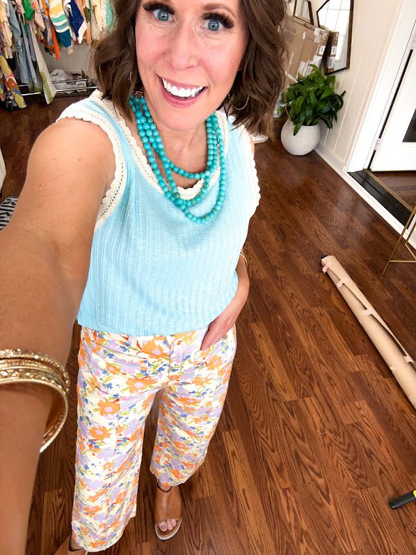 Cotton button and zipper closure bright floral pants with seams down the front of both legs and front and back pockets.